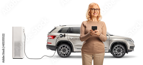 Woman with a smartphone in front of EV charging point photo