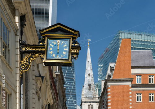 Old traditional city buildings with antique clock on St Mary at Hill street in London photo