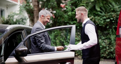 Man Giving Car Key To Male Valet photo