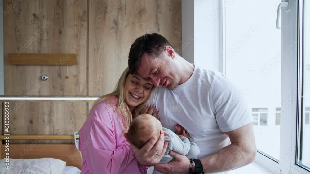 Happy new-made parent can't take away their eyes from their son. Family of three in the hospital after childbirth. Happy new-made parent can't take away their eyes from their son. Family of three in the hospital after childbirth.