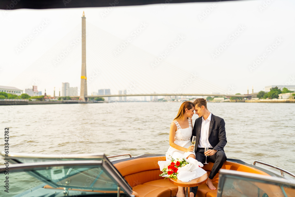 Caucasian man and woman couple relax and enjoy urban outdoor lifestyle travel city on luxury private boat yacht sailing in the river with celebrating romantic holiday event together on summer vacation