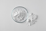 Petri dish and calcium carbonate powder on white background, top view