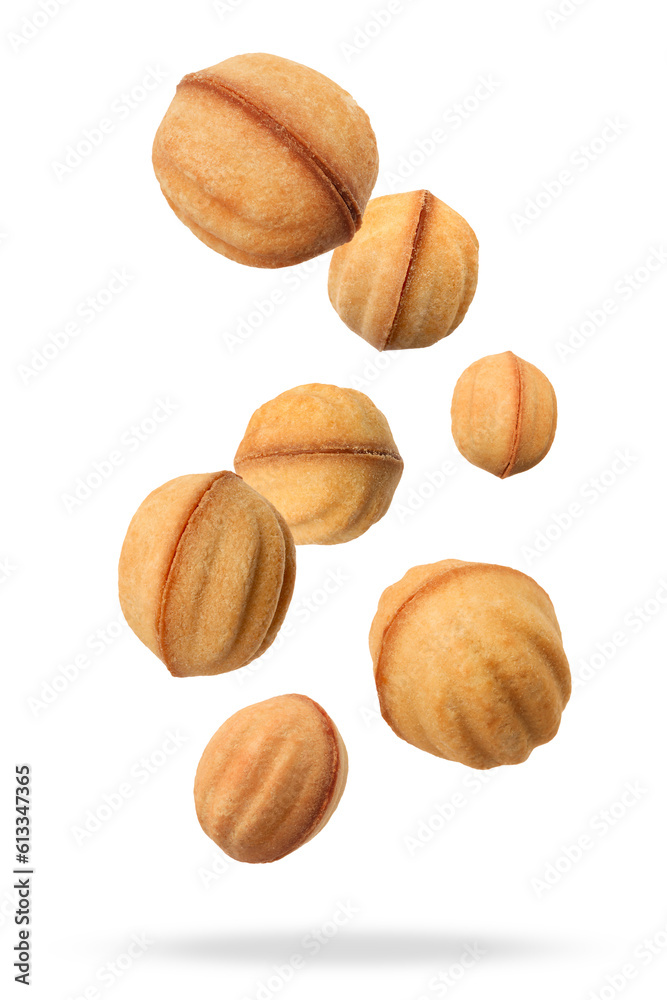 Many delicious nut shaped cookies with caramelized condensed milk falling on white background Many delicious nut shaped cookies with caramelized condensed milk falling on white background