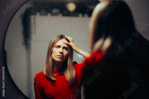 Unhappy Woman Checking her Forehead Wrinkles in the Mirror. stressed lady afraid of premature aging signs on her skin
 photo