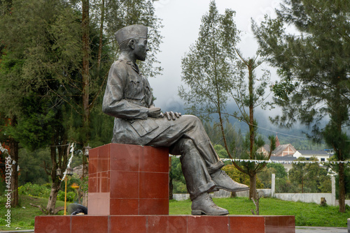 Indonesian Hero Statue Among Trees and Plants in Architectural Memorial Site photo