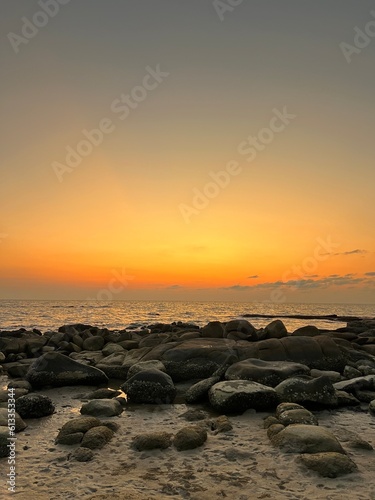 Sunset on the rock beach © witsanu