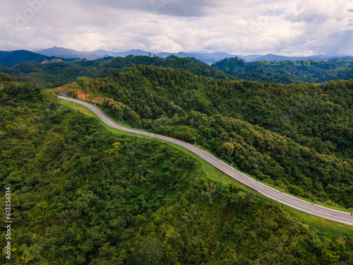 Taken from a drone camera angle at Sky Road, Road No. 3, Unseen, Nan Province, Thailand, meandering along the ridge of the forest. The view is very beautiful. The rainy season is green.