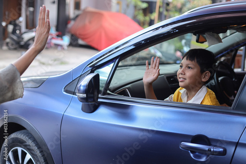 Smiling happy schoolboy waving goodbye to his mother before going to school.  © Queenmoonlite Studio