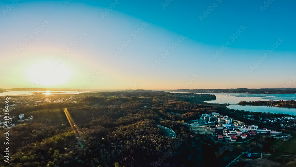 Horizontale Luftaufnahme von der Universität, der Blumeninsel Mainau und dem Bodensee beim Sonnenuntergang. Bodensee, Konstanz, Baden-Württemberg, Deutschland, Europa.