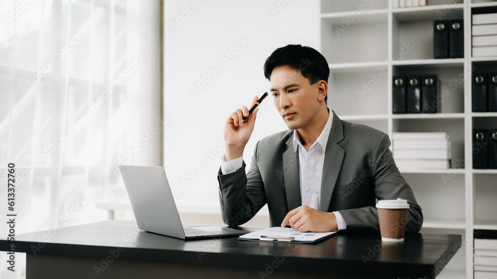 Young business man working at office with laptop, tablet and taking notes on the paper.. Young business man working at office with laptop, tablet and taking notes on the paper..