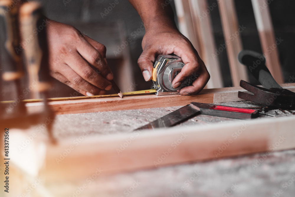 Carpenter working with equipment on wooden table, And measurement of a wooden plank Carpenter working with equipment on wooden table, And measurement of a wooden plank