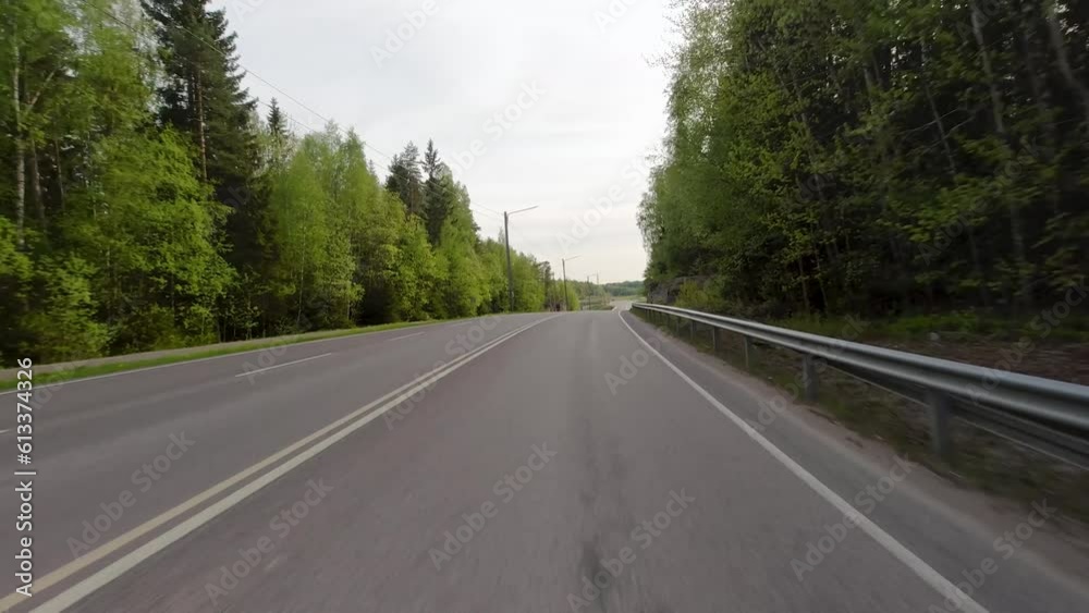 The sight of the vibrant green trees encircling the road adds a touch of natural beauty and serenity to the surroundings. The sight of the vibrant green trees encircling the road adds a touch of natural beauty and serenity to the surroundings.