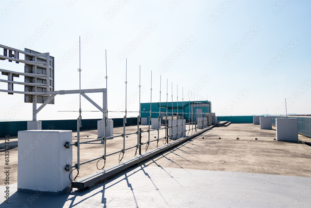 Rooftop small radio communication tower antenna and television. Sky with bright sunlight as