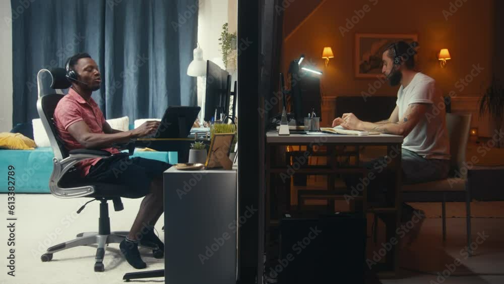 Two multiracial men talk via video call, have video conference, work remotely on computers online together. View of two rooms or apartments separated by wall. Neighbourhood and lifestyle concept. Two multiracial men talk via video call, have video conference, work remotely on computers online together. View of two rooms or apartments separated by wall. Neighbourhood and lifestyle concept.