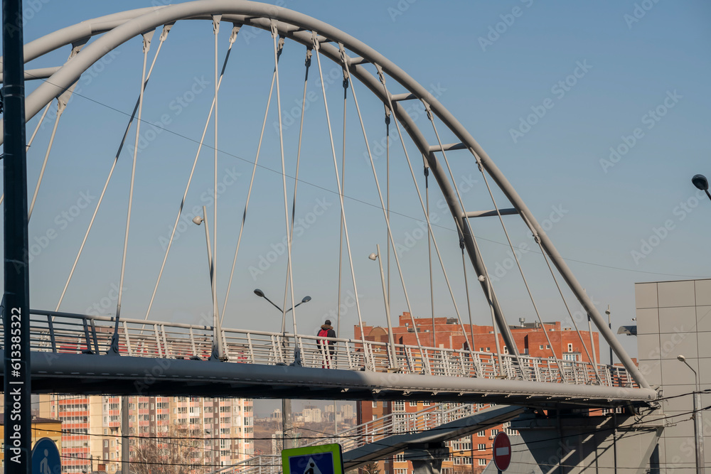 Oval arch of a pedestrian bridge over a road in the city. Oval arch of a pedestrian bridge over a road in the city.