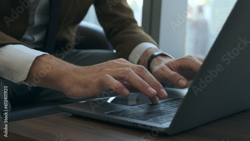 Caucasian business man's hands typing on laptop keyboard at modern office.