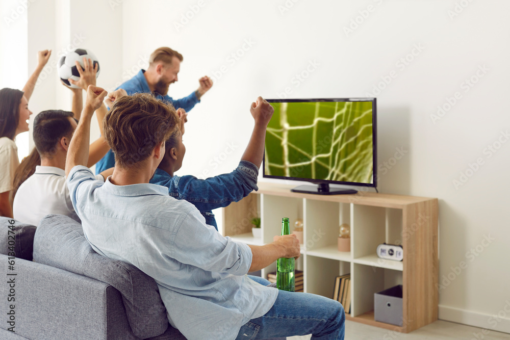 Happy, excited friends watching soccer on TV. Group of young diverse ...