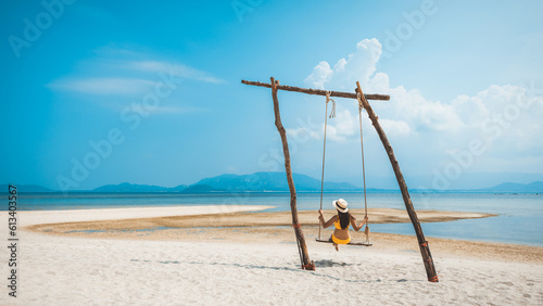 Traveler asian woman relax and travel in swing on summer beach at Koh Rap Samui in Surat Thani Thailand