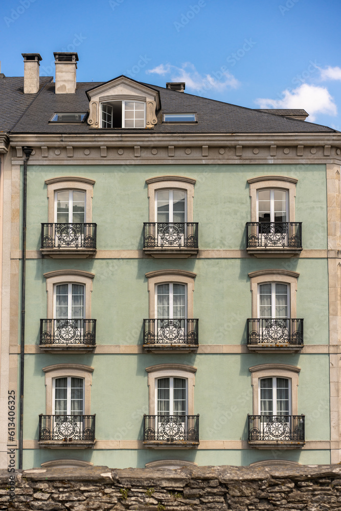 facade of a classical building with its roof, its windows in every home and balconies