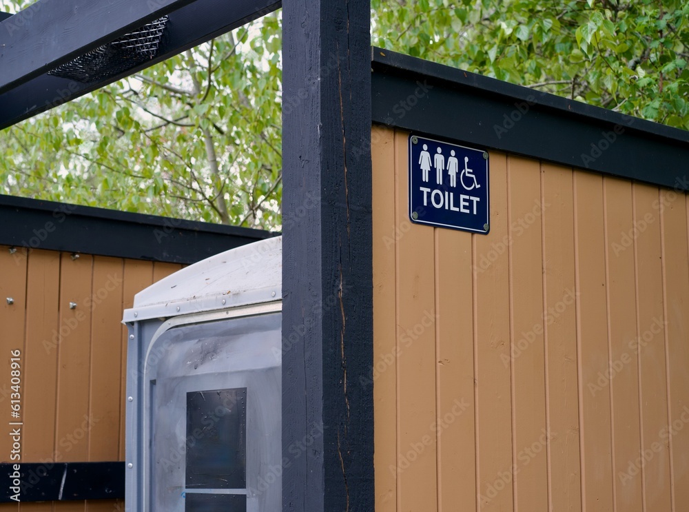 Outdoor porta potty with an all genders and handicapped accessible sign