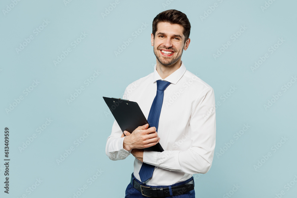 Young fun employee IT business man corporate lawyer wear classic formal shirt tie work in office hold clipboard with paper account documents isolated on plain pastel blue background studio portrait.