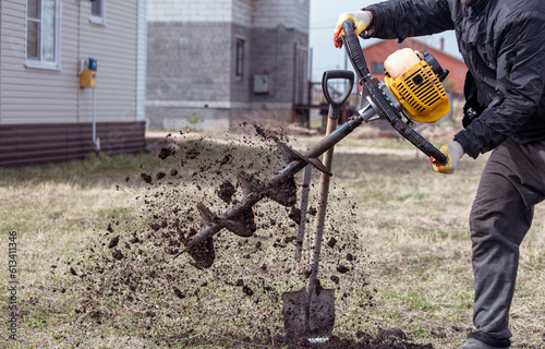 Worker digs the ground with a gasoline blower in the garden