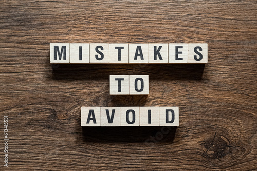 Mistakes to avoid - word concept on building blocks, text photo