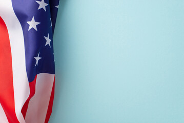 Public holiday in USA concept. High angle view photo of the flag of United States of America in the left corner on light blue isolated background with copy-space