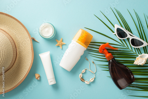 Canvas Print Sun safety essentials creatively displayed: unmarked sunblock oil and SPF cream bottles, trendy glasses, fashionable sunhat, shell bracelet, starfish, palm leaf on light blue backdrop
