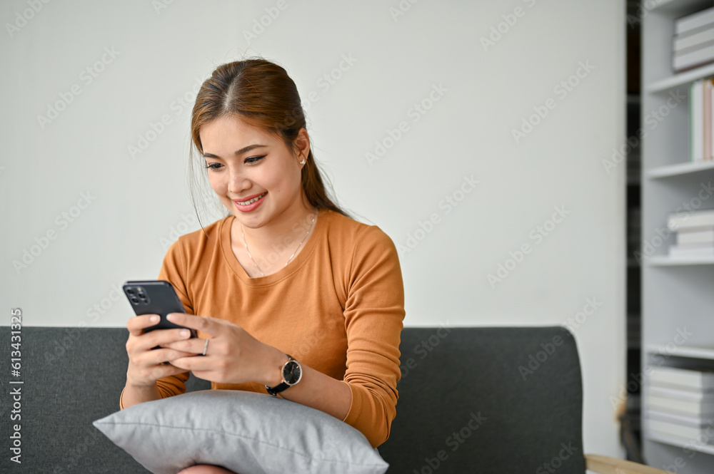 A happy woman chatting with her friends while relaxing on sofa in her living room. A happy woman chatting with her friends while relaxing on sofa in her living room.