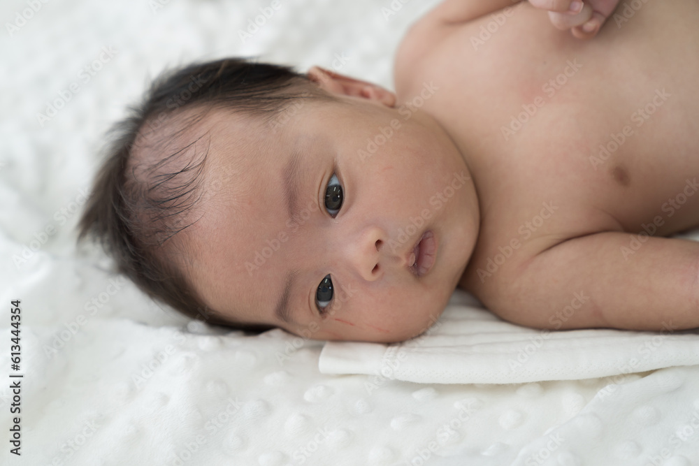 Newborn baby sleeping on blanket on white bed. Infant lying on white bed. Asian newborn baby sleeping in prone position. Asian infant Newborn baby sleeping on blanket on white bed. Infant lying on white bed. Asian newborn baby sleeping in prone position. Asian infant