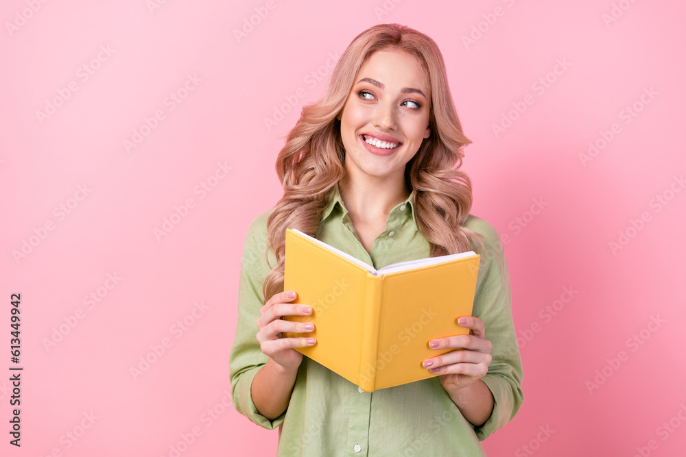 Photo of clever positive minded lady hold opened book look empty space isolated on pink color background Photo of clever positive minded lady hold opened book look empty space isolated on pink color background