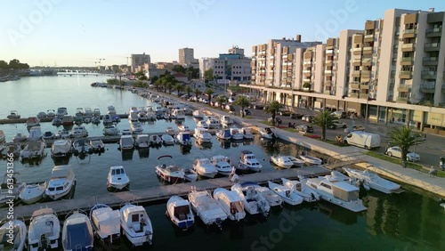 Zadar city, Jazine marina an aerial panorama at sunset with walled old town and bridge in view Croatia. Drone liftoff. photo