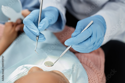 Top view closeup of dentist holding tools and mirror while working with child and dental checkup, copy space