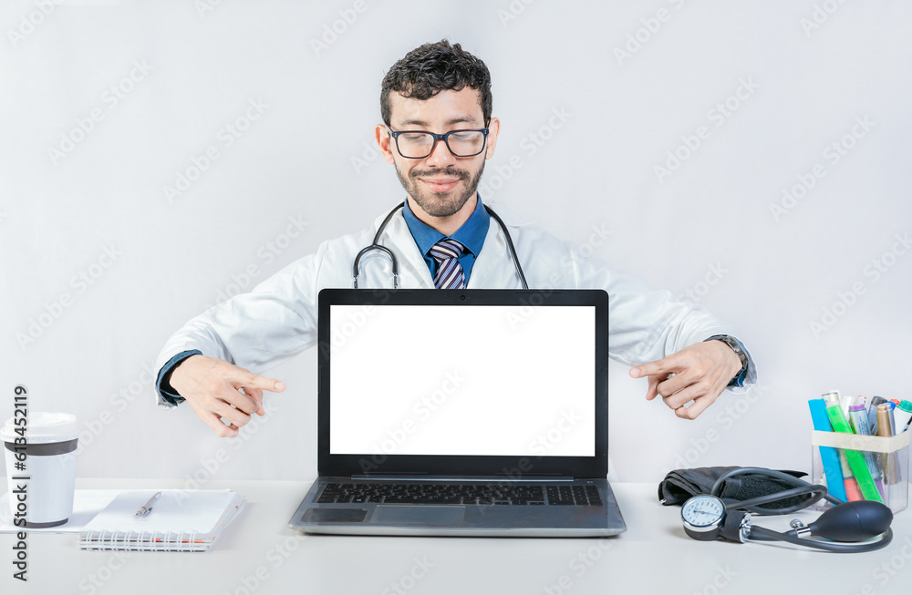 Handsome doctor pointing at an advertisement on the laptop screen. Smiling doctor pointing at an advertisement on the laptop screen Handsome doctor pointing at an advertisement on the laptop screen. Smiling doctor pointing at an advertisement on the laptop screen
