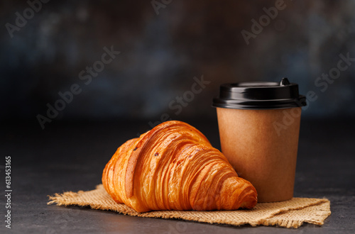 Quadro su tela Aromatic coffee in a paper cup paired with a flaky croissant