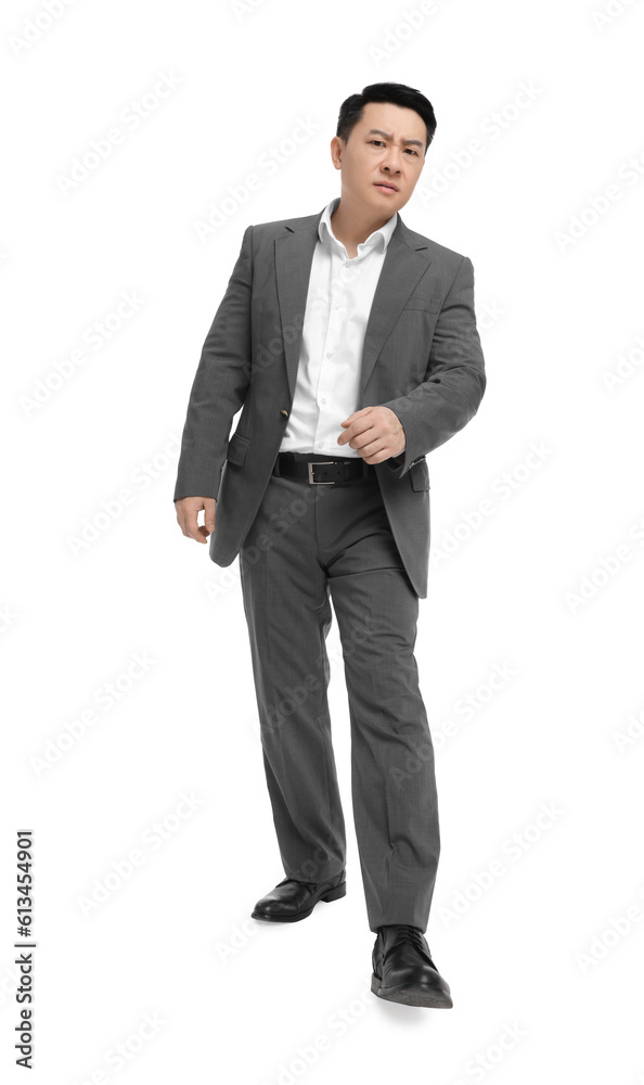 Businessman in suit walking on white background, low angle view Businessman in suit walking on white background, low angle view