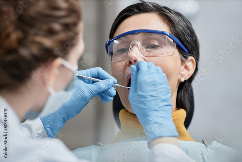 Closeup of mature woman in dental chair during teeth examination