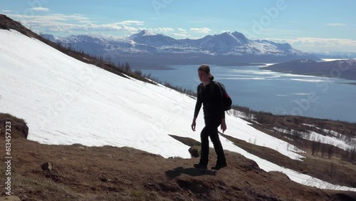 junge Frau wandert in den Bergen mit Schneelandschaft und Fjord