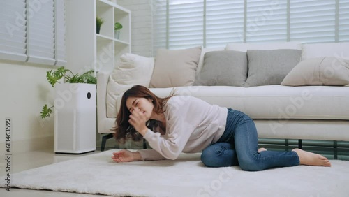 Young asian woman sick feeling dizzy and faint falling down lose consciousness on floor front of sofa in living room at home. Healthcare and medical concept