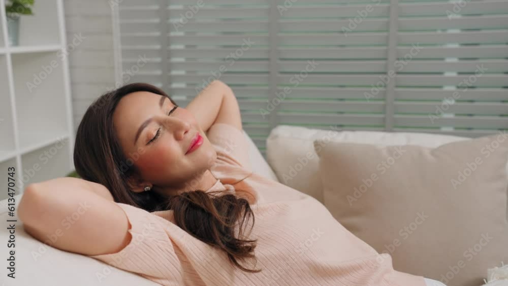 Happiness asian female in casual clothing lie down on sofa soft and comfortable sleep and relax rest in living room at home. Relax and holiday activity concept Happiness asian female in casual clothing lie down on sofa soft and comfortable sleep and relax rest in living room at home. Relax and holiday activity concept