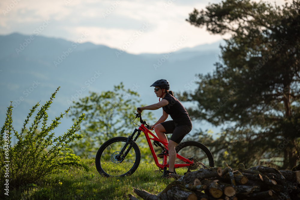 Female cycling on her mountain bike through the countryside on a sunny day.