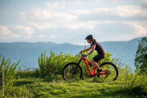 Female cycling on her mountain bike through the countryside on a sunny day.