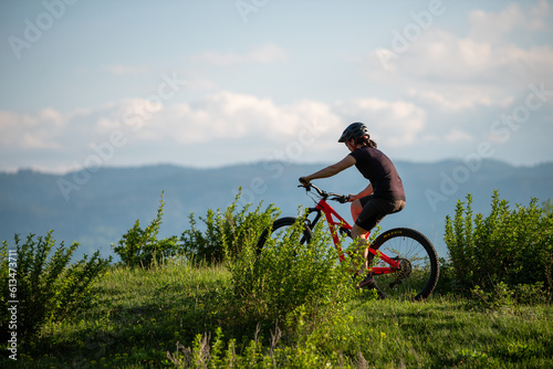 Female cycling on her mountain bike through the countryside on a sunny day.