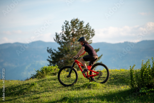 Fototapeta Naklejka Na Ścianę i Meble -  Female cycling on her mountain bike through the countryside on a sunny day.