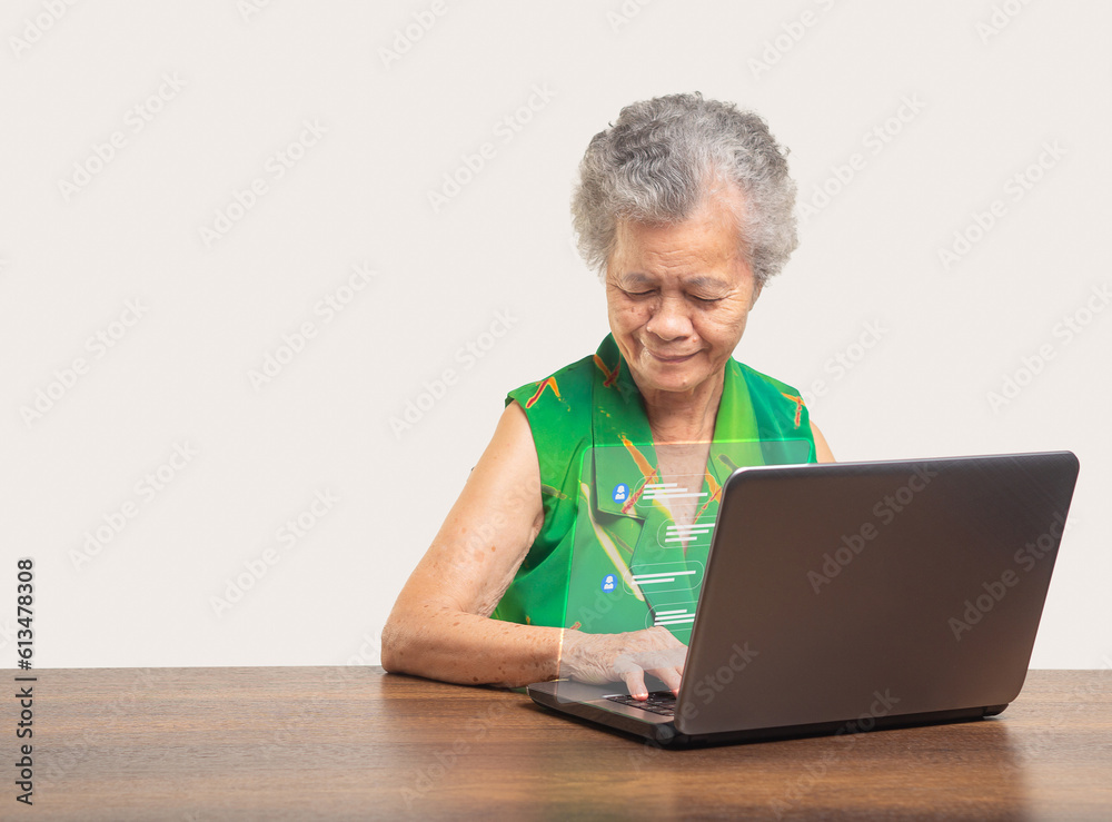Beautiful elderly Asian woman typing on a keyboard laptop with live chat chatting on application communication digital media websites and social networks. Beautiful elderly Asian woman typing on a keyboard laptop with live chat chatting on application communication digital media websites and social networks.
