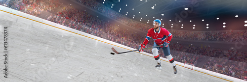 Young man, professional hockey player in red uniform in motion with puck and stick during competition on 3D ice rink, arena. Concept of sport, competition, match, game, action and motion