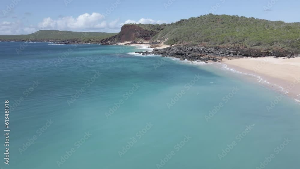 Aerial-Drone shot of turquoise water empty white sand beach on sunny day.Sideway