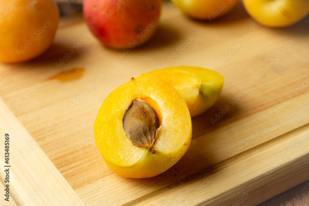 Apricots lying on a wooden board, freshness, harvesting, autumn mood, beautiful decoration with a kitchen towel.