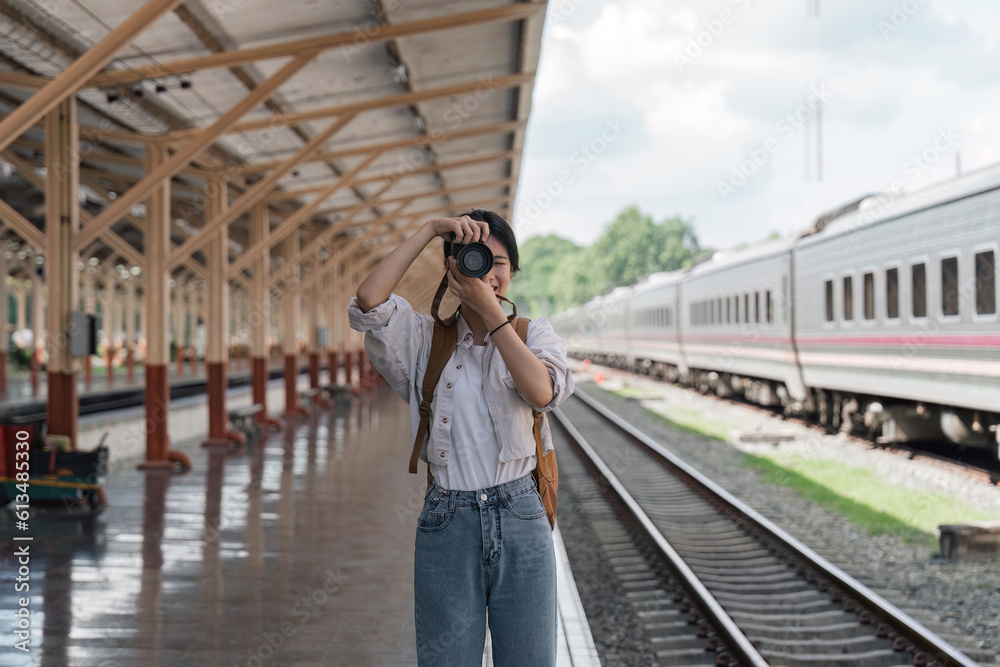 Traveler girl taking photo in train station